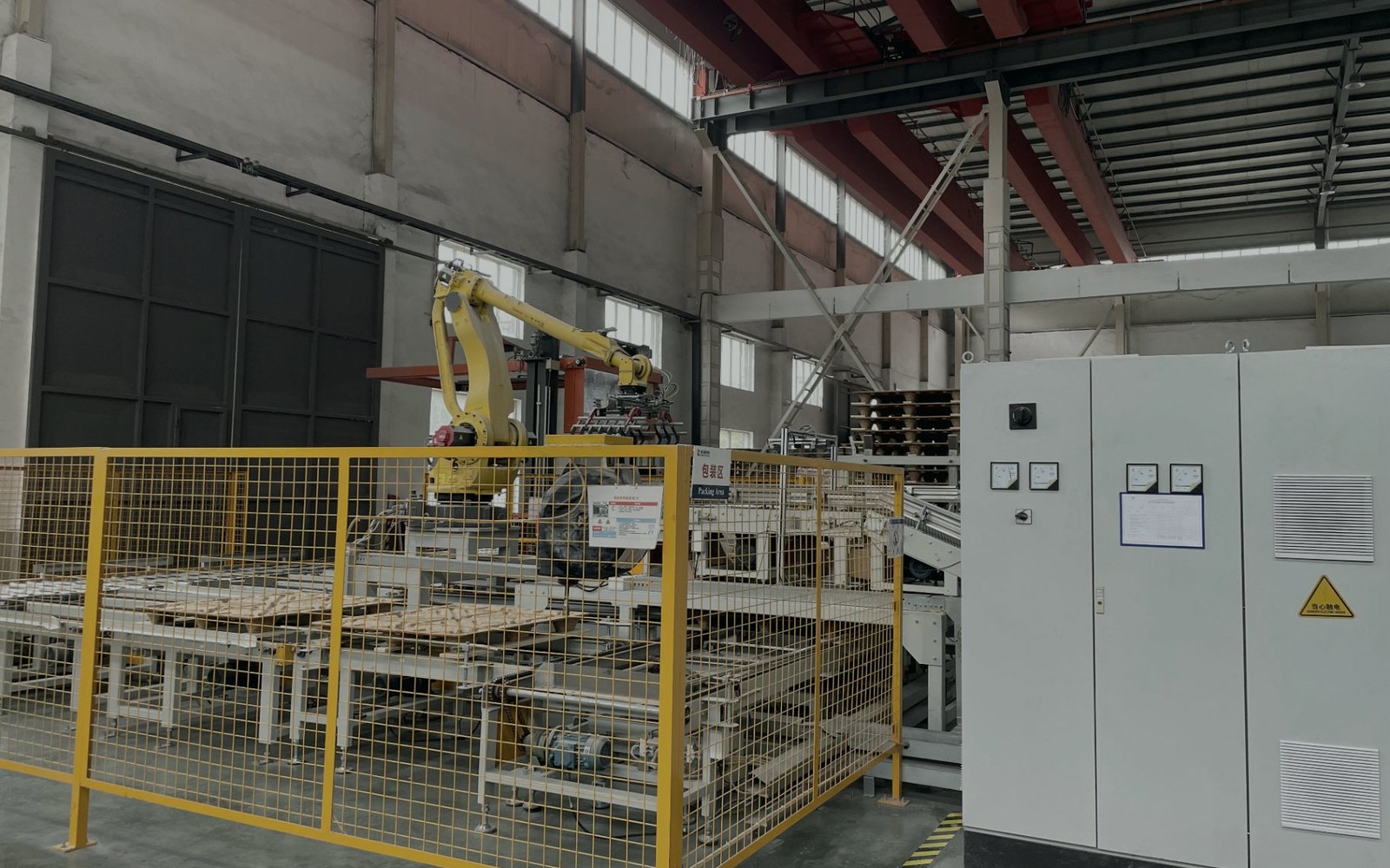 Robotic palletising arm behind a safety fence